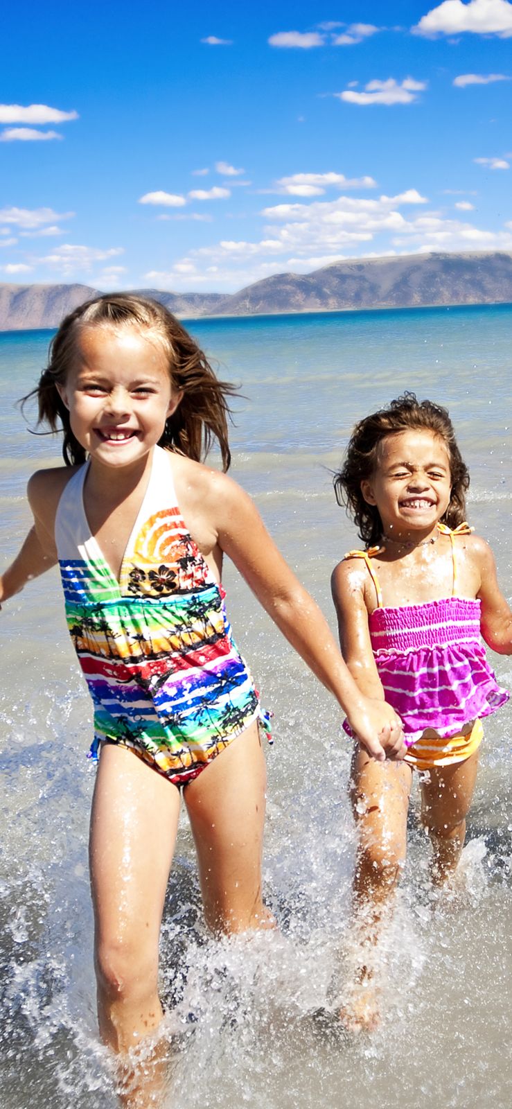 Children running into the waves
